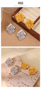 Detail of square layered earrings showing wrinkled texture and polished metallic finish