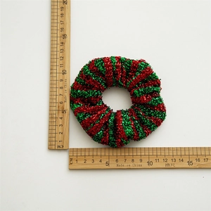 Glitzerndes Haargummi in Rot und Grün mit weihnachtlicher Metallic-Samt-Textur