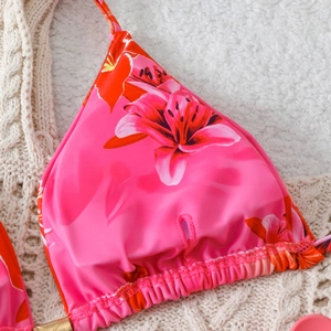 Close-up of pink lily floral print bikini top with ruffled triangle cups and soft fabric
