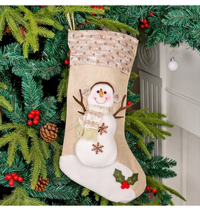 Dettaglio calza di Natale in lino con pupazzo di neve 3D appesa a un albero festoso