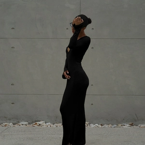 Détail de la robe noire ajustée à manches longues avec découpe sexy sur le devant