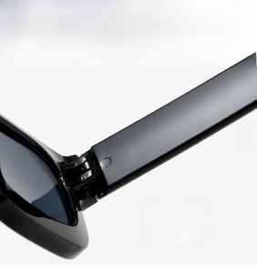 Detailed macro view of the sturdy metal hinge construction on these thick frame sunglasses