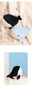 Close-up of soft whale plush toys in black and blue colors with striped belly details
