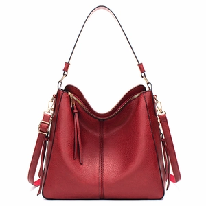 Detailed view of the dark red faux leather tote bag with long tassel and gold hardware
