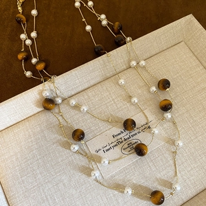 Collier vintage avec perles blanches et pierres œil de tigre sur chaîne dorée