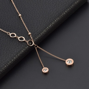 Rose gold titanium Y-necklace with Roman numeral pendants on black leather background