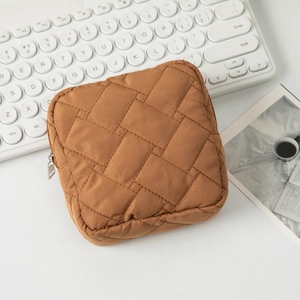 Vue détaillée d'une trousse à maquillage matelassée caramel avec fermeture éclair argentée
