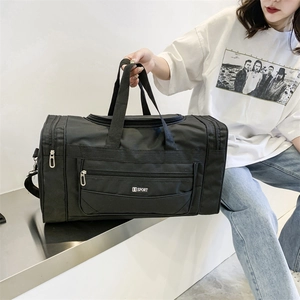 Detail of a large black nylon travel bag featuring the S SPORT embroidery and side pocket