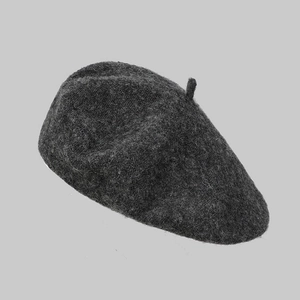 Close-up of dark grey wool beret showing soft textured fabric and vintage stitching