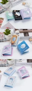Close-up of mini photo albums with colorful cartoon patterns and cutout heart windows