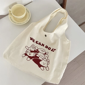 Détail du sac cabas en toile montrant le bouton pression en bronze et l'imprimé animal