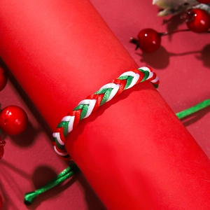 Close-up of red, green, and white woven Christmas bracelet on a festive display