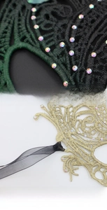 Detailed view of Venetian lace mask featuring intricate embroidery and sparkling rhinestones