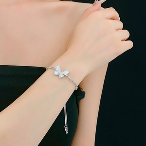 Détail du bracelet papillon argenté avec zircons blancs et chaîne réglable coulissante
