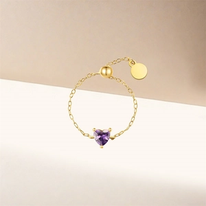Detail of adjustable gold chain ring featuring a heart-shaped purple zircon stone