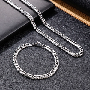 Men's silver stainless steel Cuban link chain necklace and bracelet set on black background