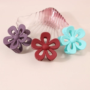 Macro detail of matte floral hair claws in purple, burgundy and light blue colors
