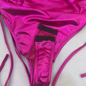 Detailansicht des metallisch-rosa Bodys mit dem Dreifach-Druckknopfverschluss im Schritt