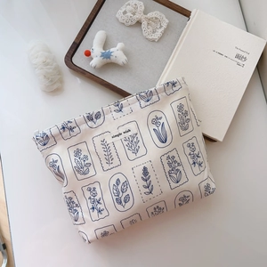 Detailed close-up of a floral cotton makeup bag with top metal zipper and minimalist label