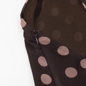 Detail eines unsichtbaren Reißverschlusses auf braunem Chiffonstoff mit Punkten