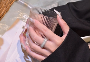 Detailed view of luxury silver 925 multi-row pave crystal band ring on finger