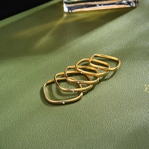 Set di cinque anelli quadrati minimalisti in oro rosa con zirconi su sfondo in pelle verde