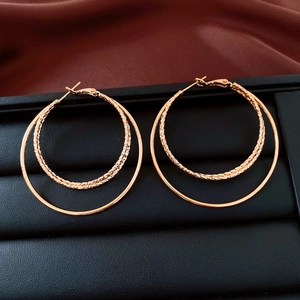 Vue détaillée des boucles d'oreilles doubles créoles plaquées or 18 carats avec textures