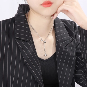Collier à franges argentées avec pendentif haltère minimaliste porté par un mannequin