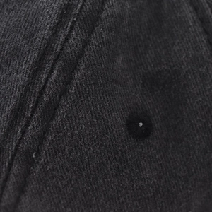 Close-up of black washed cotton baseball cap featuring reinforced stitching and eyelets