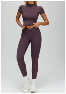 Detail of high-waisted yoga leggings with V-shaped cross waistband and matching zipper top