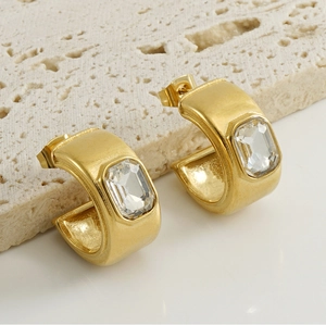 Détail de boucles d'oreilles en C plaquées or 18K avec zircon rectangulaire sur pierre