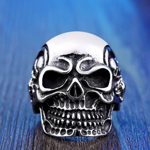 Close-up of vintage silver gothic skull ring with detailed texture on blue background