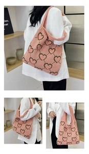 Vue en trois cadres d'un sac cabas en tricot rose avec des motifs de cœurs verts sur un mannequin