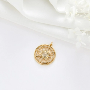 Détail de pendentif soleil doré avec zircons brillants sur fond de satin blanc