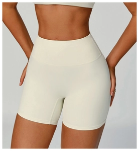 Close-up of high-waisted beige yoga shorts showing elastic waistband and fabric texture