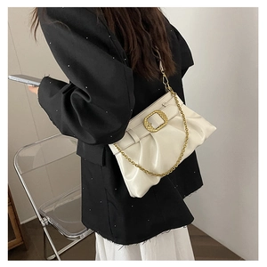 Détail du sac à main plissé blanc brillant avec boucle dorée et bandoulière chaîne