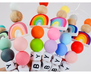 Detail of DIY baby pacifier clip with rainbow silicone beads and natural beech wood
