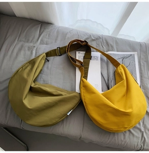 Detail view of large capacity nylon crescent bags in olive green and bright yellow colors