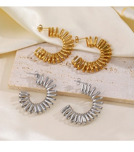 Detailed close-up of 18K gold and silver C-shape twisted earrings on stone