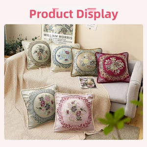 Detail of vintage floral embroidery on satin cushion covers in a cozy home setting
