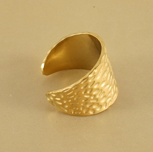Macro detail of 18K gold plated wide band ring with hammered texture and open design
