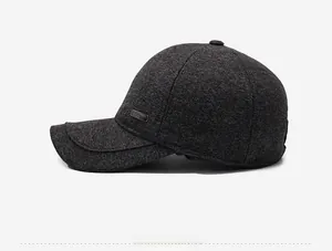 Side view of dark gray knit baseball cap with thick warm lining and metal plaque detail