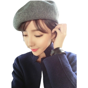 Women's grey wool beret hat in a classic solid color octagonal design on a model