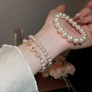 Détails de bracelets en perles plaqués or 18k avec zircon sur le poignet d'un modèle