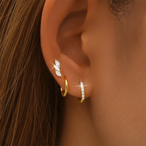 Close-up of gold s925 silver earring set with marquise zircon studs and small hoop earrings