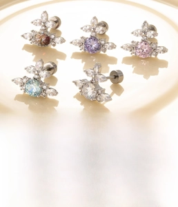 Macro detail of titanium steel Saturn stud earrings with radiating zircon stones