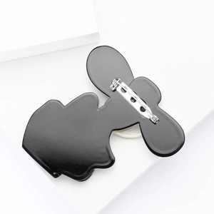 Detail view of the metal safety pin and closure on the back of the acrylic brooch