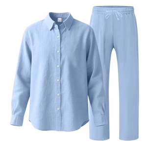Détail d'un ensemble bleu clair en lin avec chemise et pantalon à cordon et texture de tissu