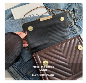 Detail view of brown quilted crossbody bag featuring dual golden magnetic snap closures