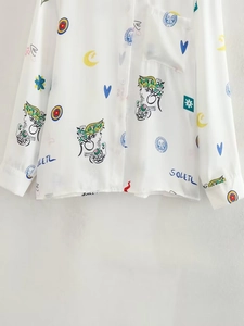 Détail d'imprimé graffiti artistique sur chemise blanche à manches lanterne évasées